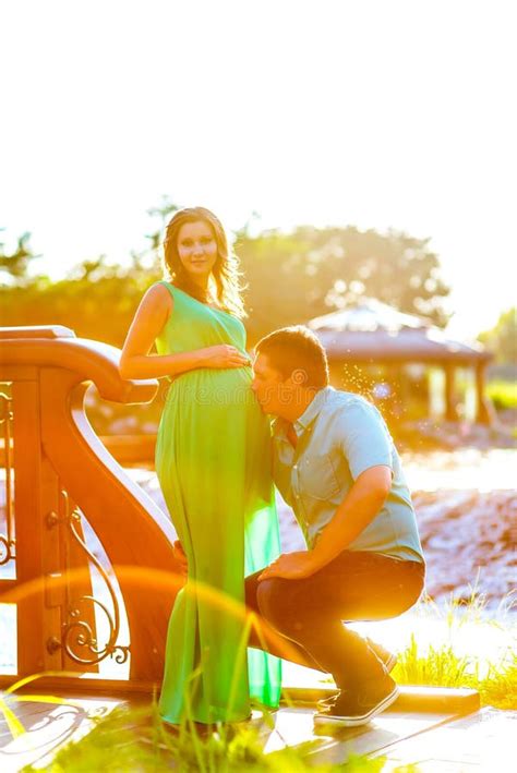 El Hombre Joven Feliz Se Besa El Vientre Embarazada De La Esposa Foto