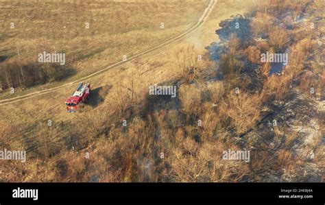 Aerial View Spring Dry Grass Burns During Drought Hot Weather Bush Fire And Smoke Fire Engine