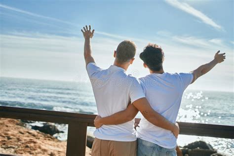 Joven Pareja Gay En Vista Trasera Mirando Al Horizonte En La Playa Imagen De Archivo Imagen De