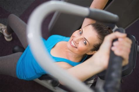 Premium Photo Fit Brunette Using Weights Machine For Arms
