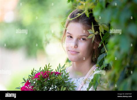 A Brunette Teenager Girl With A Bouquet Of Summer Flowers Poses For The Camera Stock Photo Alamy