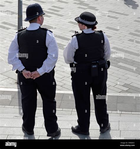 Back view male & female Metropolitan police officers in uniform outside ...