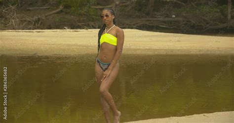 Slim Sexy Model Posing In A Bikini With A Shallow River Flowing In The