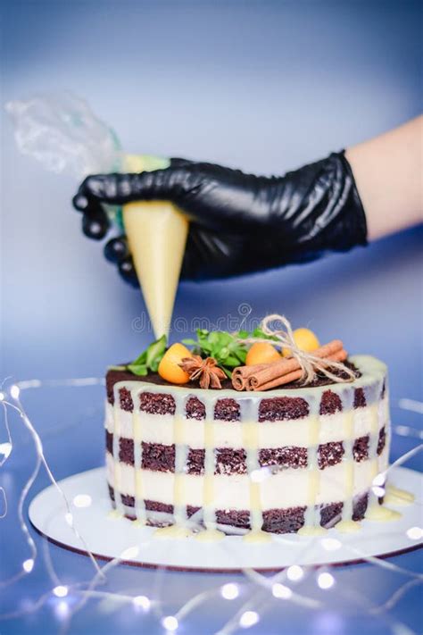 A Pastry Chef Decorates A Chocolate Naked Cake With Drips Of White