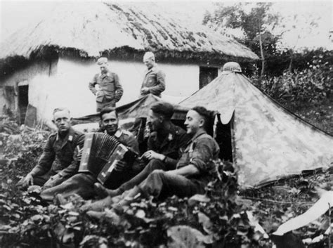 Солдаты дивизии «Герман Геринг» на отдыхе во дворе у деревенского дома ...