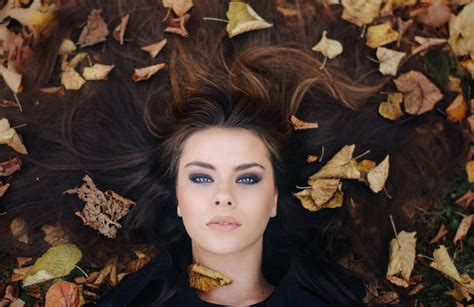 Closeup Photo Of Woman Wearing Black Top Lying On Brown Surface Beside Leaves Hd Wallpaper