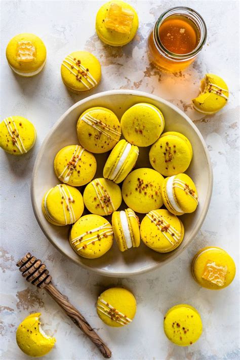 A Bowl Filled With Yellow And White Decorated Cookies