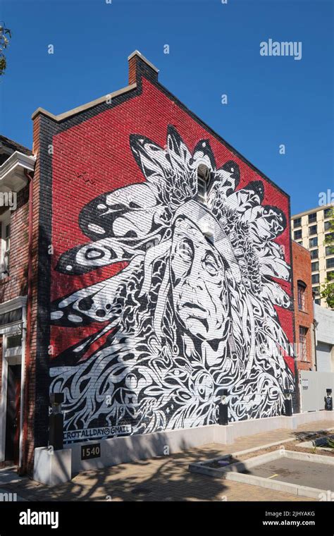 Un Enorme Mural En Una Pared De Ladrillo Rojo Con Un Retrato De Un