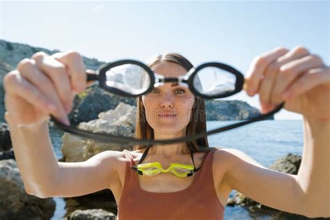 Retrato De Flaca Joven En Bikini De Punto Marrón Sentado En La Roca Costera Imagen de archivo