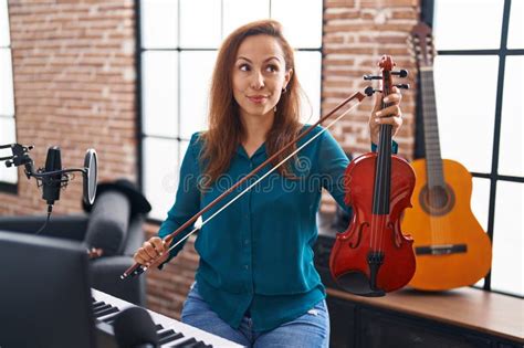 Brunette Woman Playing Violin Smiling Looking To The Side And Staring Away Thinking Stock Photo
