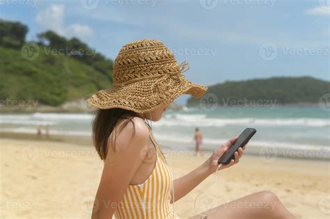 Jeune Belle Femme En Bikini Coutant De La Musique Et Utilisant Un Smartphone Sur La Plage L