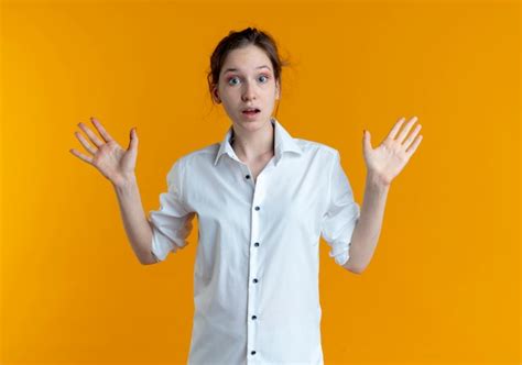 Jeune Fille Russe Blonde Choquée Se Tient Avec Les Mains Levées Isolé Sur L espace Orange Avec
