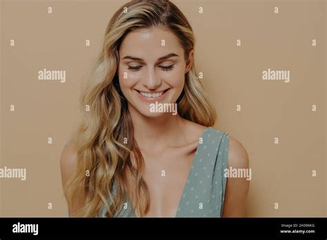 Schüchtern schüchtern junge hübsche blonde Frau schaut mit einem Lächeln nach unten