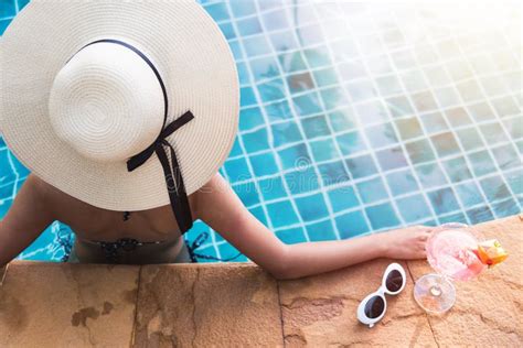 Los J Venes Apoyan A La Mujer En C Ctel De La Bebida De La Piscina Del Bikini Imagen De Archivo