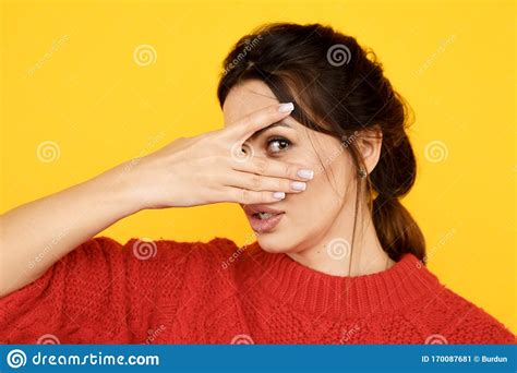 Femme Cachant Son Visage Et Observant Par Ses Doigts Image Stock