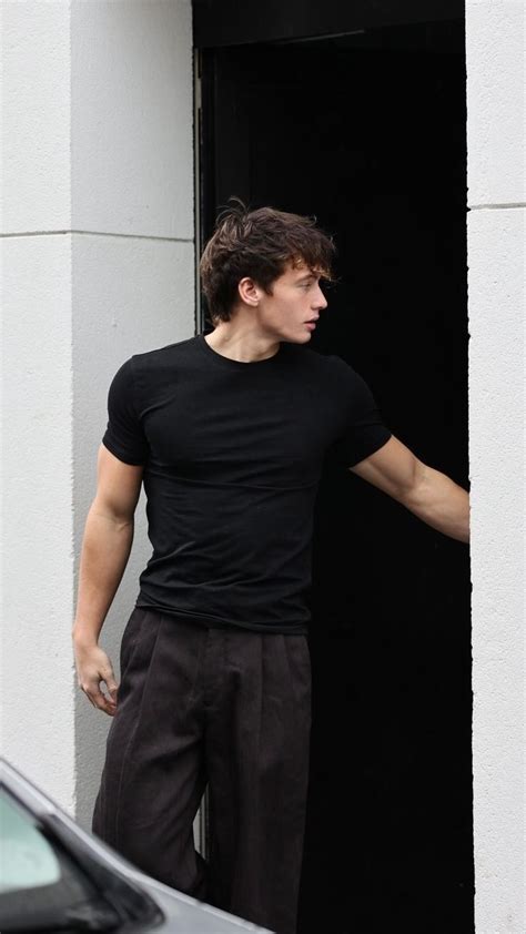 A Man In Black Shirt Standing Next To A Door With His Hand Out And