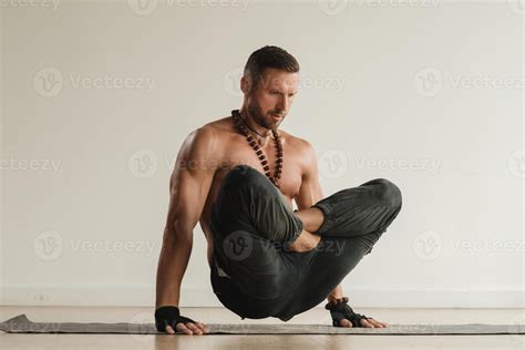 A Man With A Naked Torso Does Yoga Standing On His Hands Indoors Fitness Trainer 39914266 Stock
