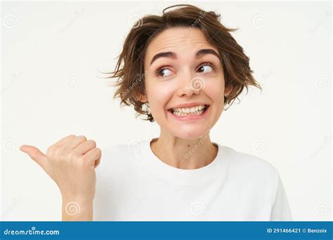 Image Of Excited Brunette Woman With Short Haircut Pointing Left Smiling And Looking Happy