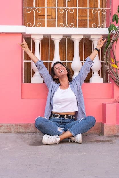 Mujer Latina Sentada Con Las Piernas Cruzadas En La Calle Foto Premium