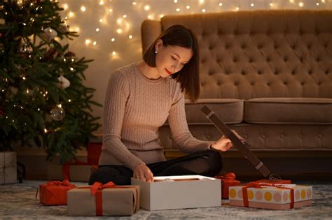 Free Photo Pretty Brunette Woman Opens An Adorable Present Holding A White Christmas Globe