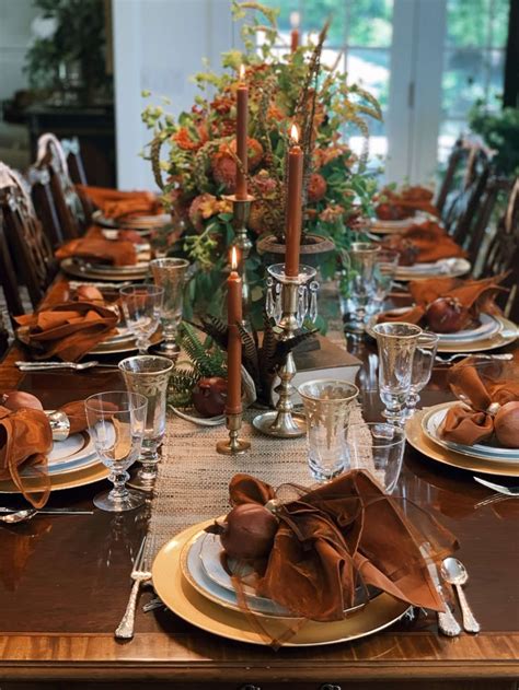 A Table Set With Plates Silverware And Candlesticks For Thanksgiving