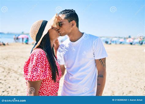 Joven Pareja Latina Abrazándose Y Besándose En La Playa Foto de archivo