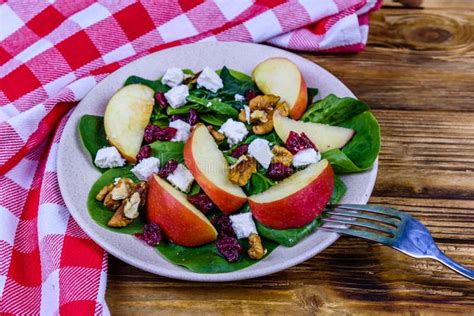 Salad With Spinach Leaves Feta Cheese Cranberries Walnuts And Apple In A Ceramic Plate Stock