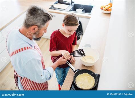 Top View Of Mature Father With Small Son Indoors In Kitchen Making Pancakes Stock Image