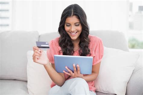 Smiling Cute Brunette Sitting On Couch Holding Credit Card And Tablet Stock Photo Image Of