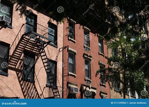 Row Of Colorful Old Brick Residential Buildings With Fire Escapes In