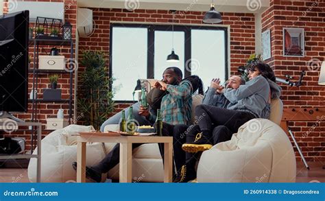 Diverse People Getting Scared Watching Horror Movie On Television Stock
