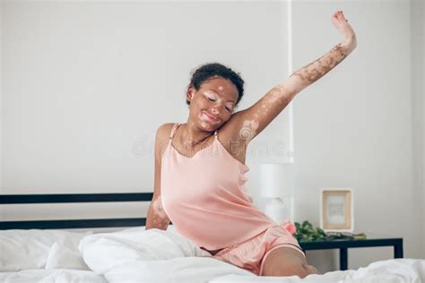 Uma Jovem Bonita Sentada Na Cama De Lingerie Rosa E Esticada Imagem De Stock Imagem De Calmo