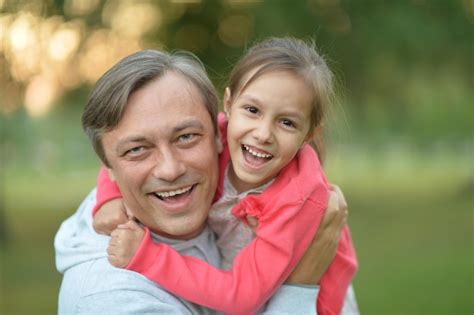 Padre abrazando a su pequeña hija en la naturaleza Foto Premium