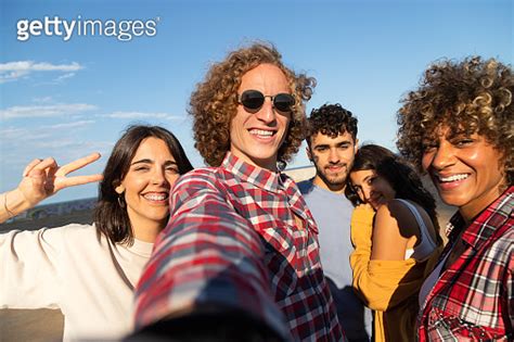 Group Of Multiracial Friends Take Selfie Having Fun Outdoors Looking At