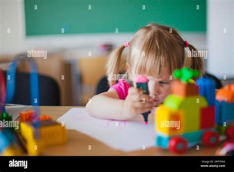 Toddler Girl Drawing Paper Classroom Stock Photo Alamy