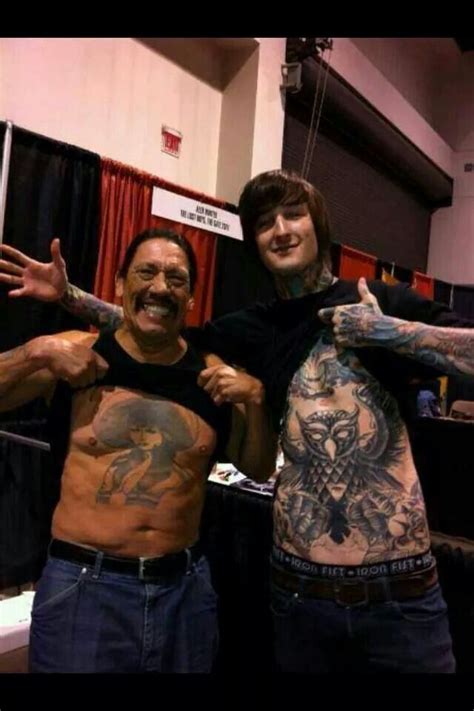 Two Men Standing Next To Each Other With Tattoos On Their Arms And