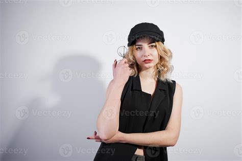 Studio Portrait Of Blonde Girl In Black Wear And Cap Against White Background 10500415 Stock
