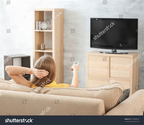 Beautiful woman watching TV while resting on sofa at home 站酷海洛 正版图片 视频