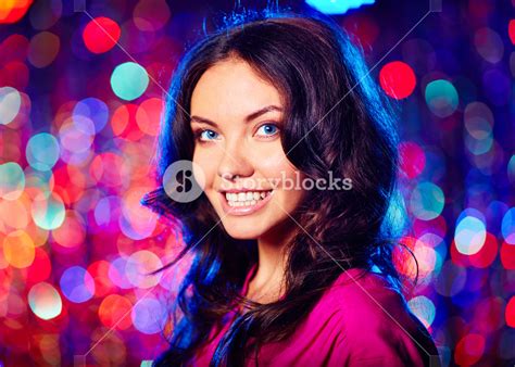 Portrait Of Beautiful Brunette Looking At Camera With Toothy Smile Over Sparkling Background