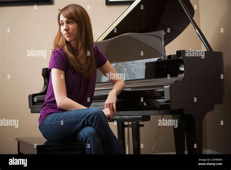 Young Woman Sitting By Grand Piano Stock Photo Alamy