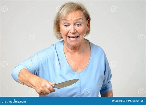 Elderly Woman Brandishing A Kitchen Knife Royalty Free Stock