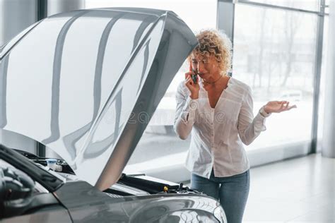 Car Is Damaged Hood Is Opened Woman With Curly Blonde Hair Is In Autosalon Stock Image Image