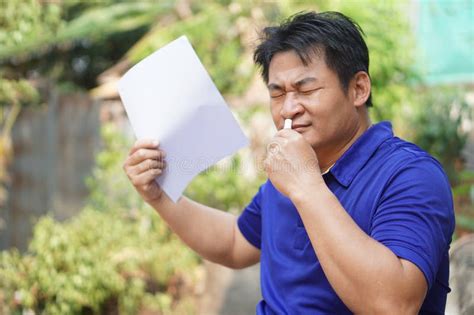 Asian Man Feel Hot Unwell Use Menthol Inhaler To Smell Hold Paper To Fan For Relief Symptom