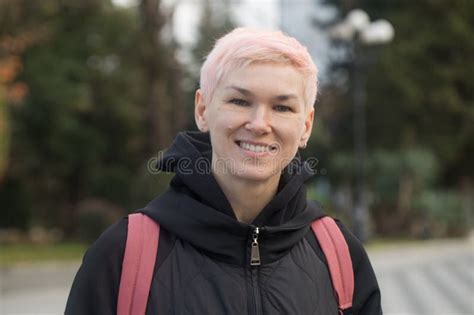 Mature Woman With Short Hair Smiling Standing And Looking At Camera Outdoors Portrait Stock