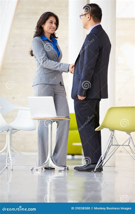 Businessman and Businesswoman Shaking Hands in Modern Office Stock ...