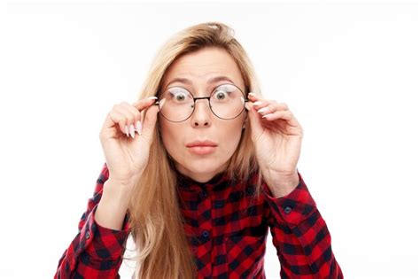 Le visage d une fille blonde choquée avec des lunettes a l air surpris en gros plan sur fond de