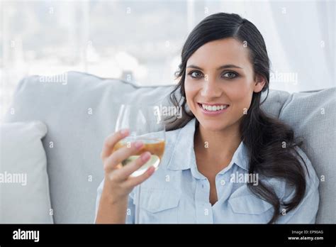 Seductive Brunette Drinking White Wine On Sofa Stock Photo Alamy