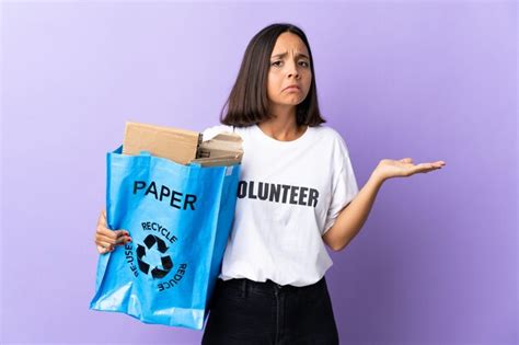 Joven Latina Sosteniendo Una Bolsa De Reciclaje Llena De Papel Para Reciclar Aislado En P Rpura