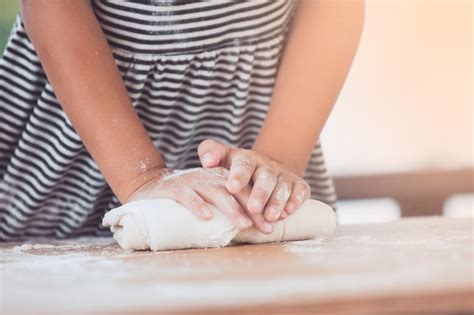 Hände des kleinen kindermädchens teig kneten bereiten sich für