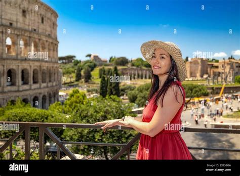 Brunette Girl With Straw Hat Admires The Majesty Of The Colosseum And In The Background The
